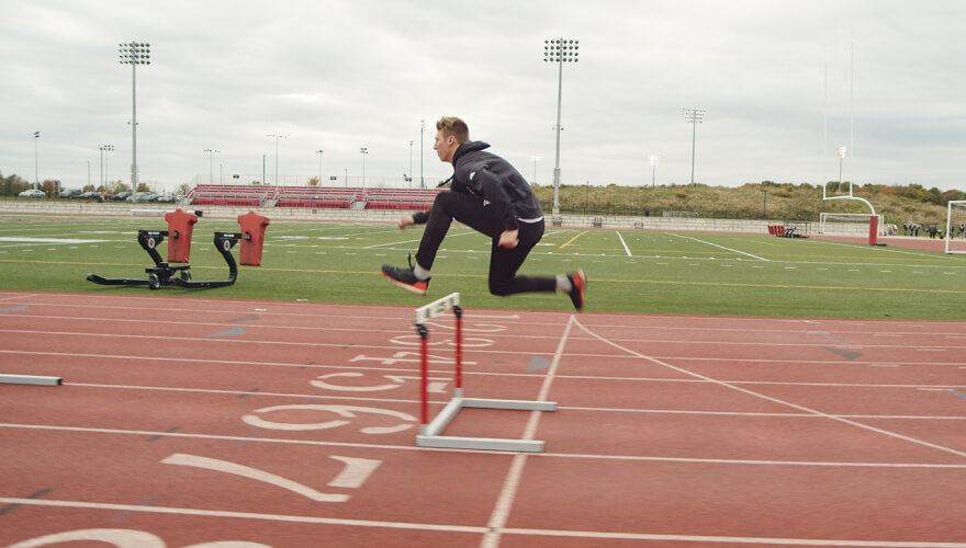 student on track doing hurdles