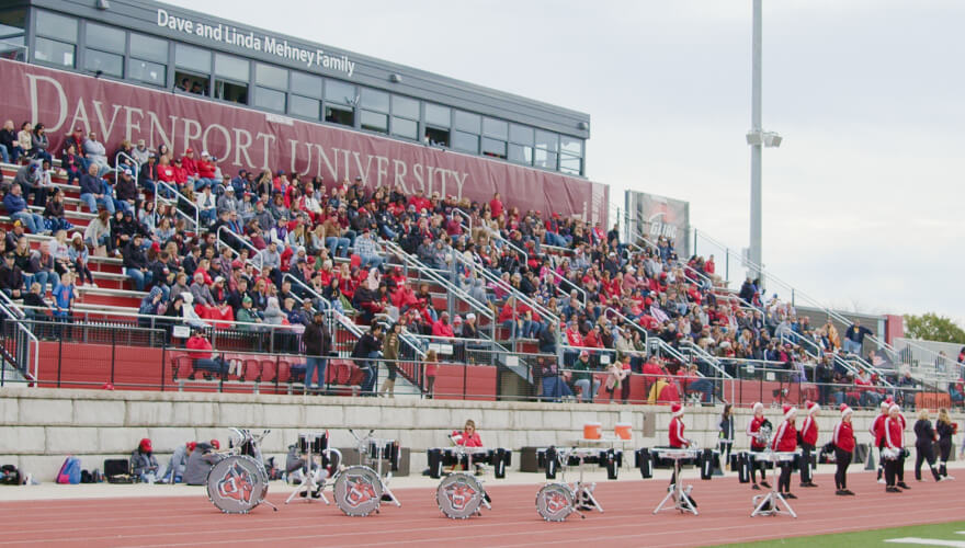 students and fans in football stadium seating