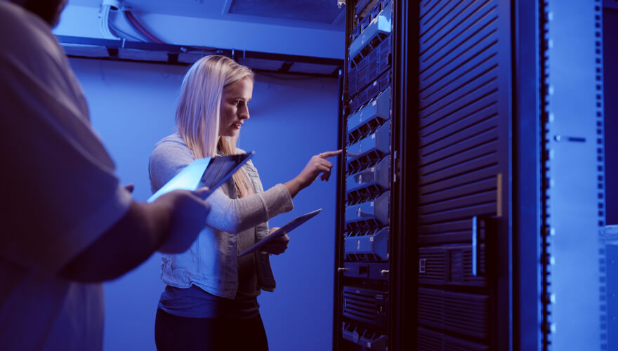 student touching a network server in server room