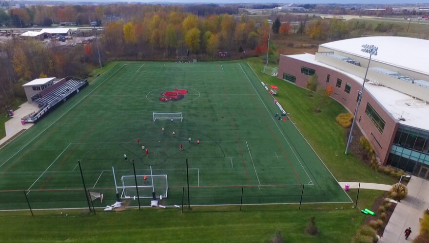 overhead view of turf field with individuals playing soccer