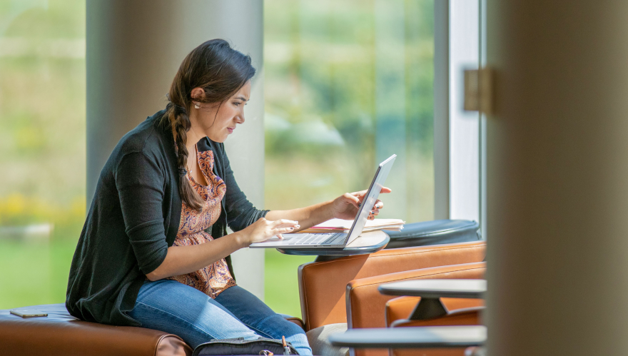 Student on laptop studying in library