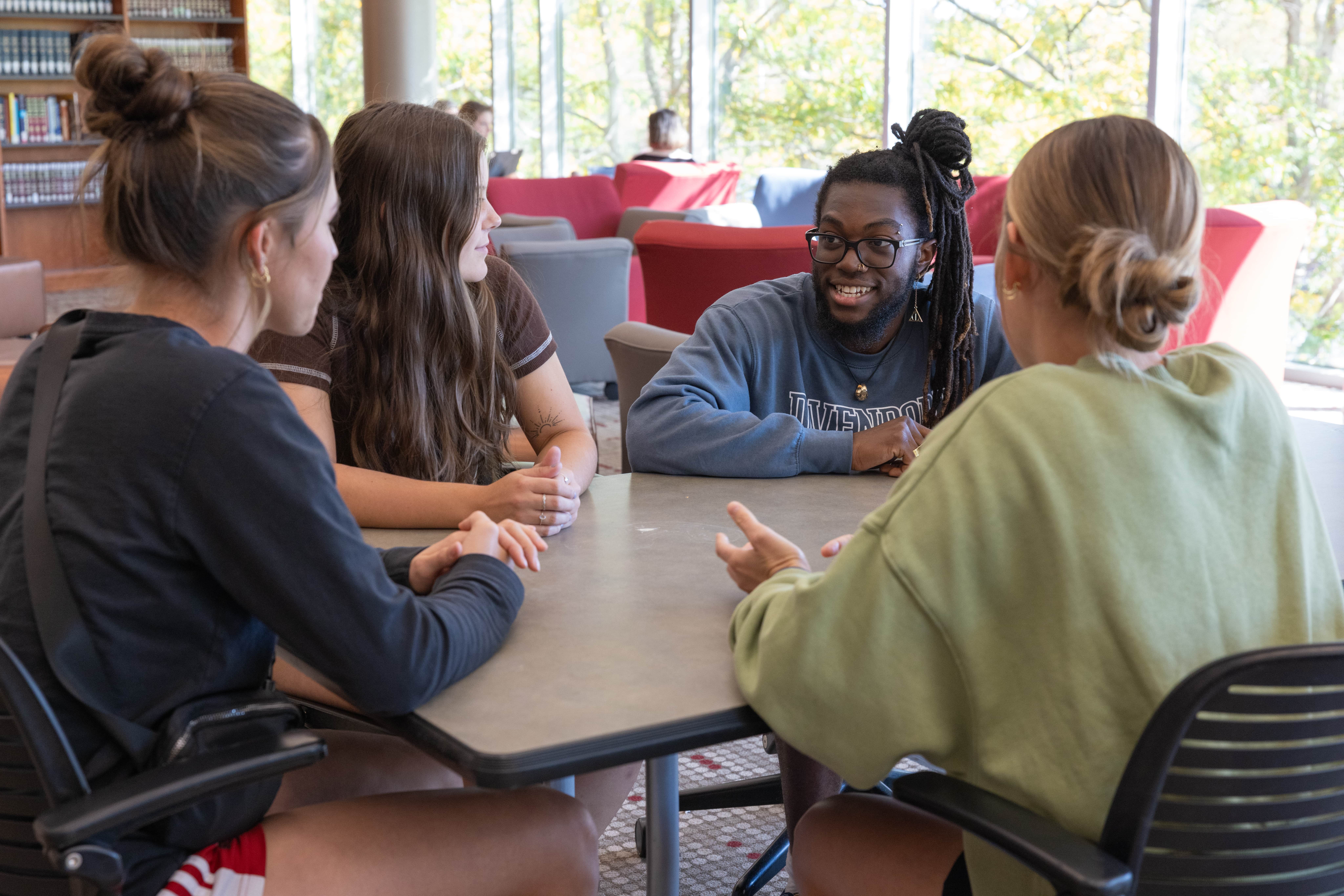 Four students at a table in the Center for Learning Engagement on the Lettinga Grand Rapids campus.