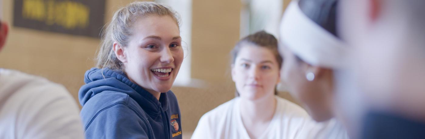 student smiling in dining hall with friends