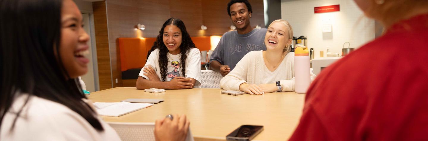 a group of students gathered around a table at the Hub
