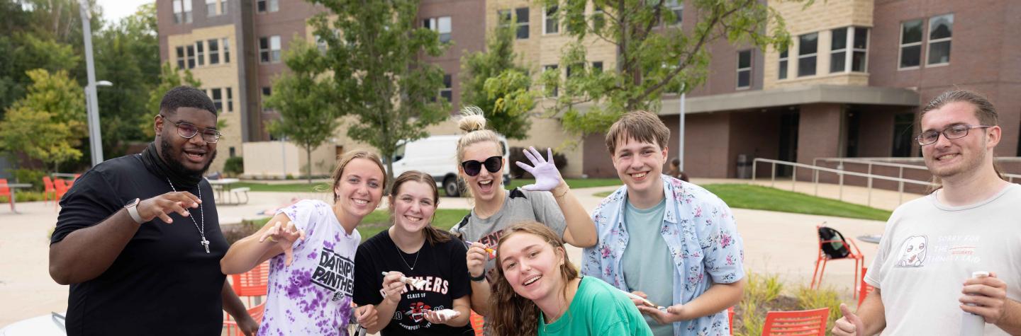 Group of students painting outside of the residence halls