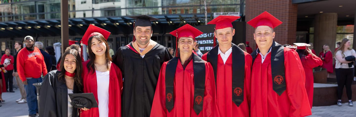 Six DU students in caps and gowns from the 2025 DU Commencement ceremony
