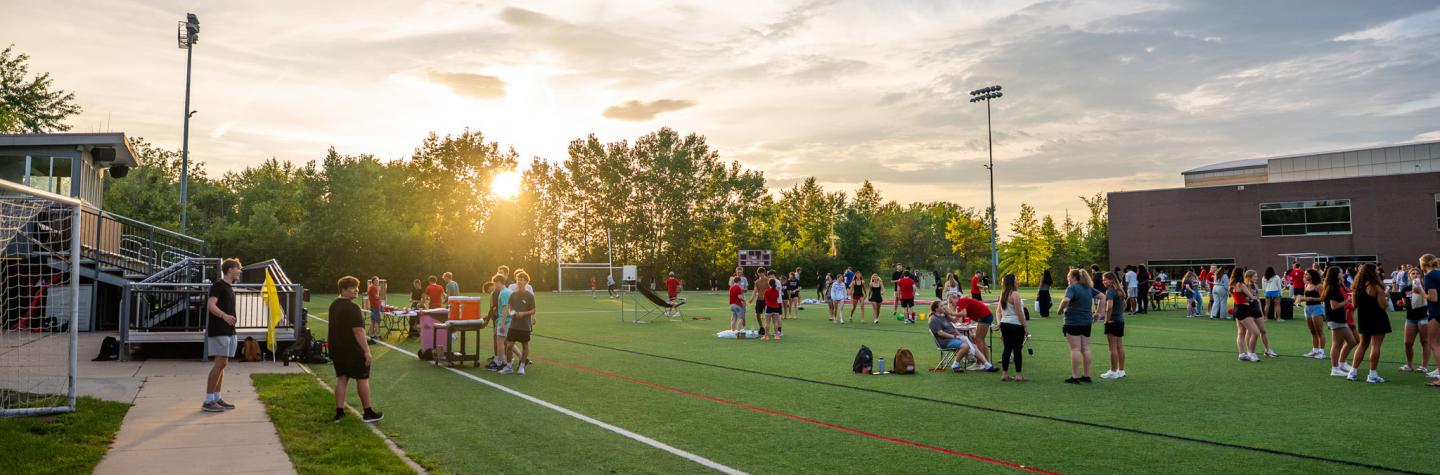 Students on the turf field at sunset