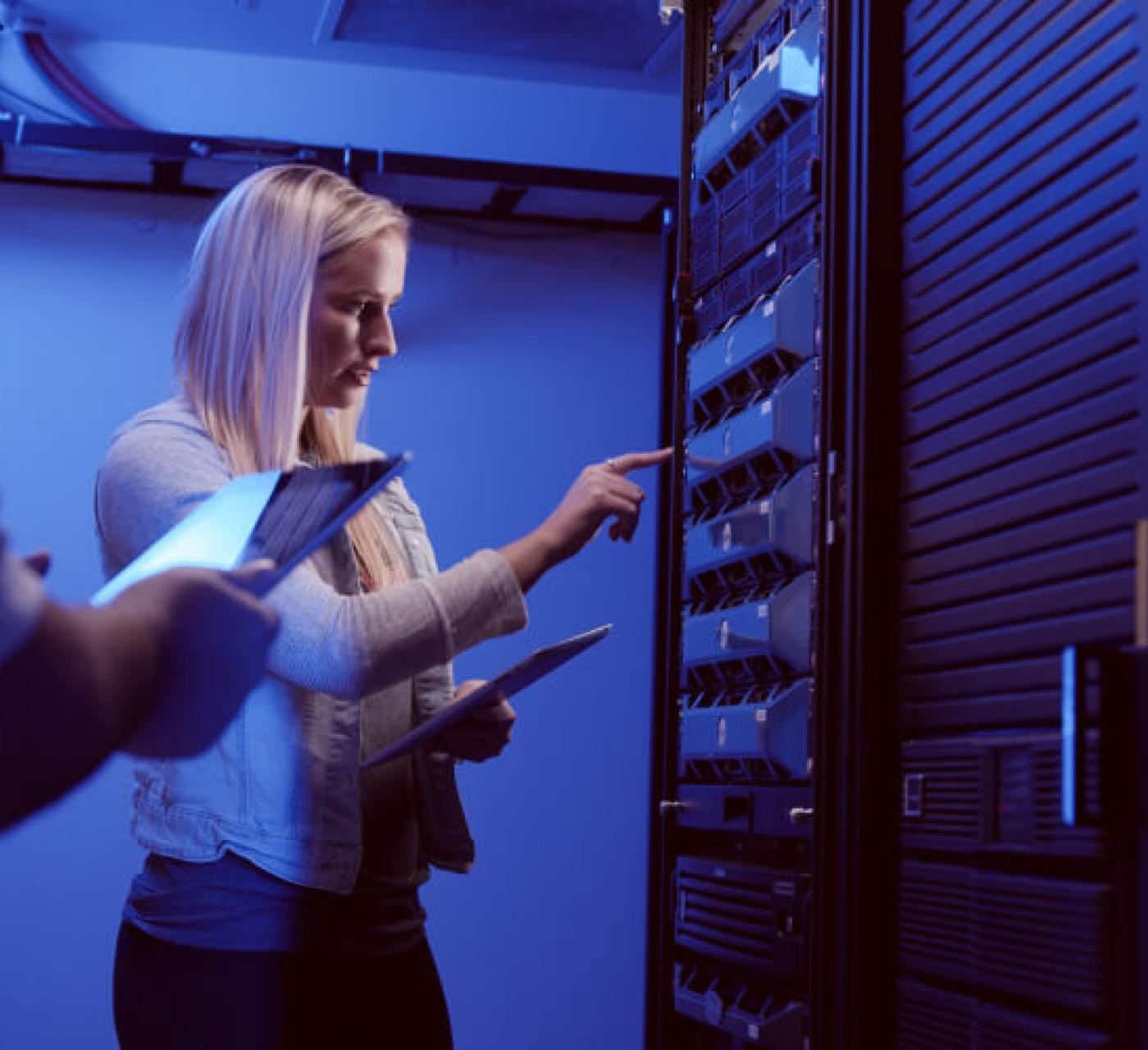 student touching a network server in server room
