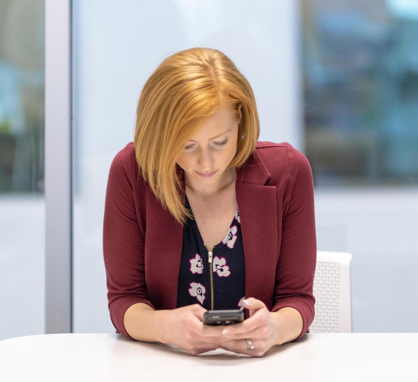 woman in business attire looking at phone