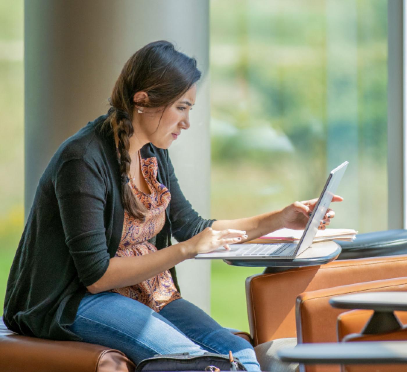 Student on laptop studying in library