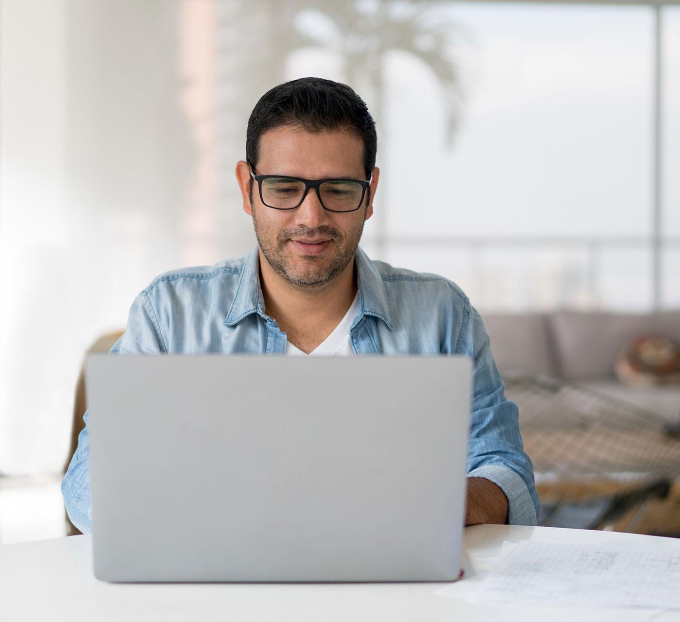 Adult man with glasses on a laptop