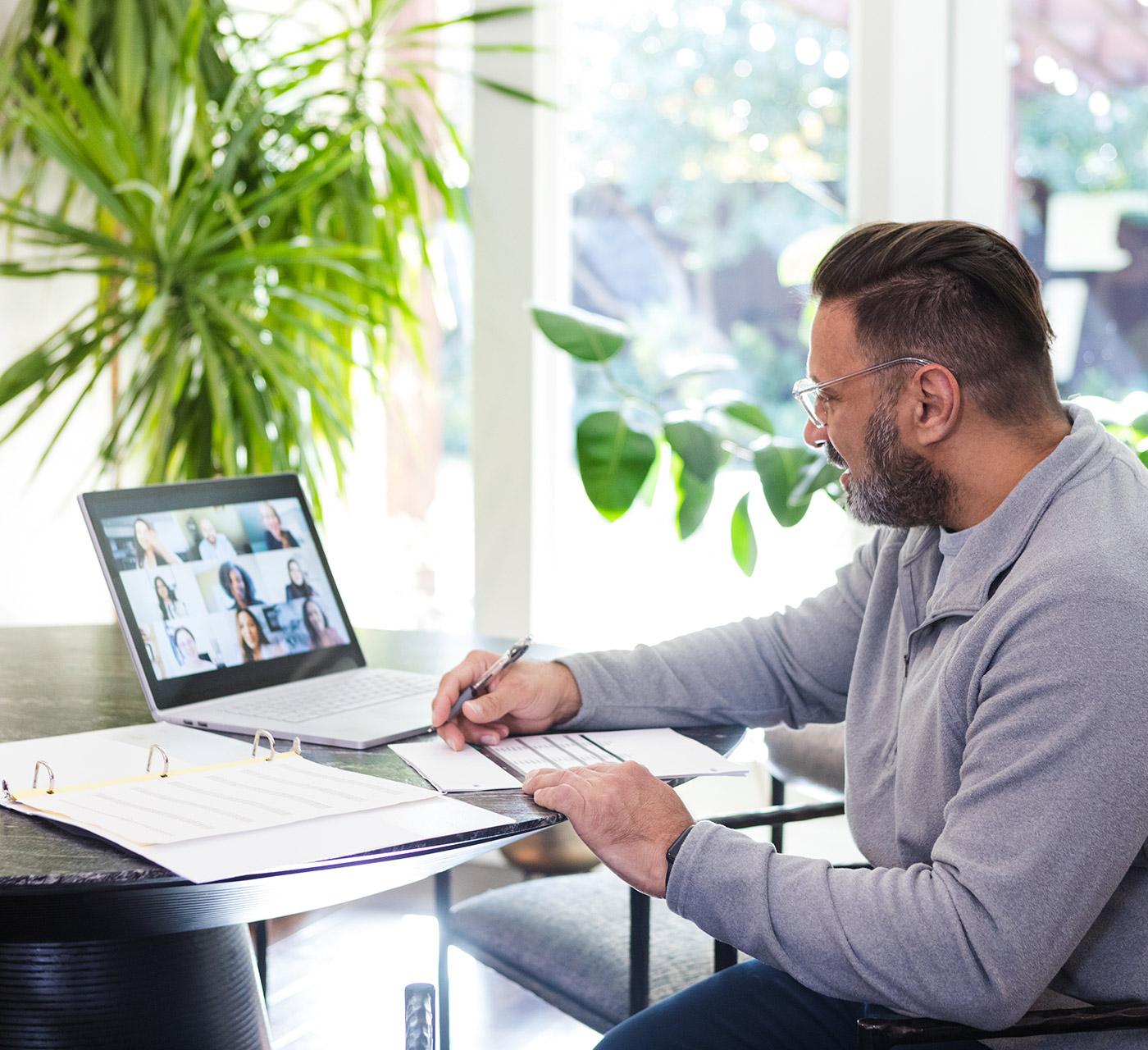 Adult male professional on a virtual meeting on his laptop