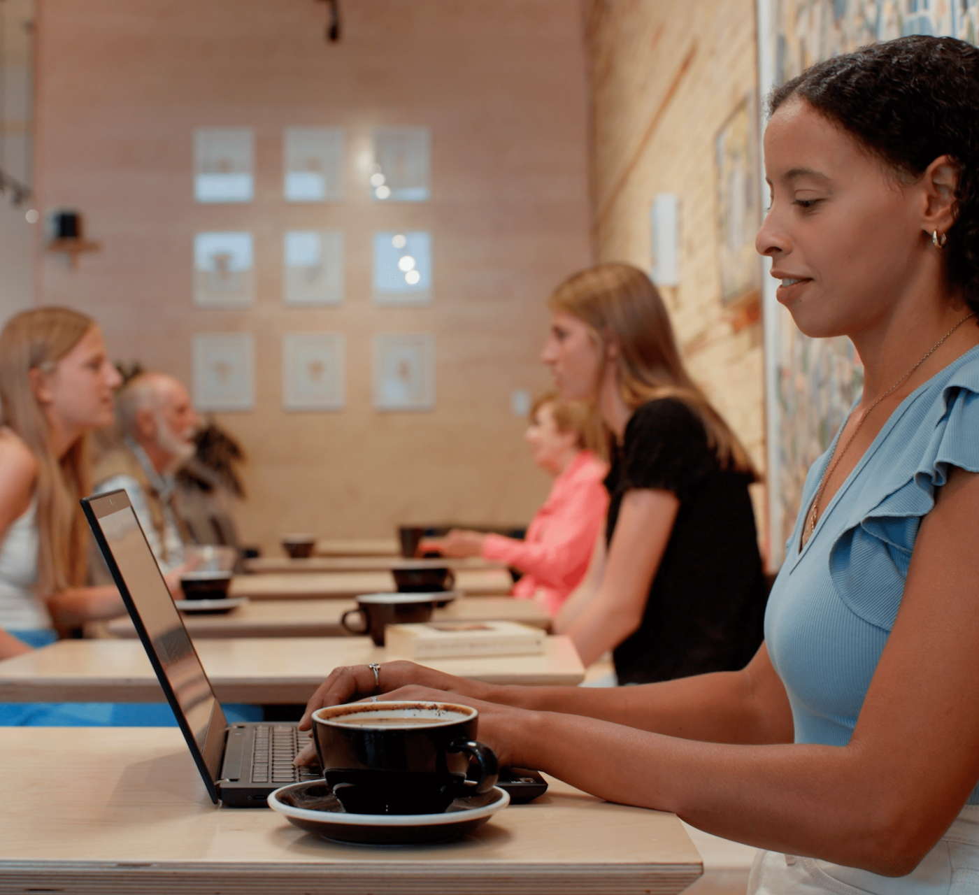Female at a coffee cafe table on her laptop