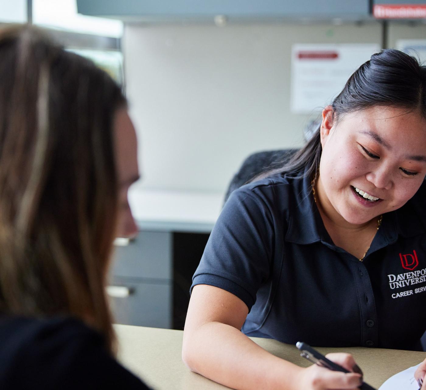 A female career services employee working with a student in the career services office