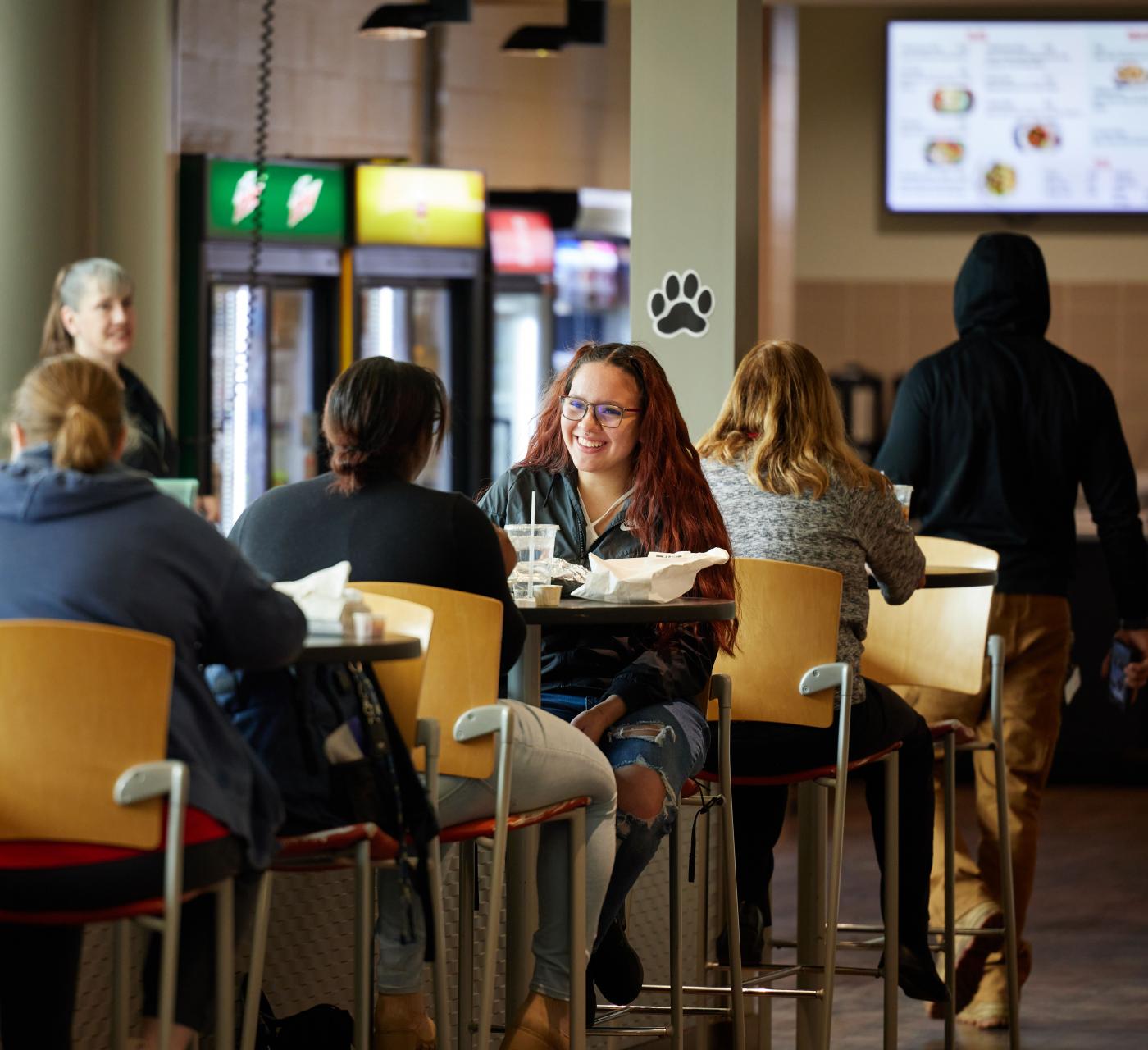 A group of students eating in the Panther Den dining area