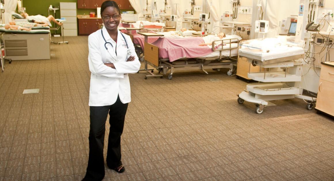 Nurse in a white coat standing in a hospital classroom