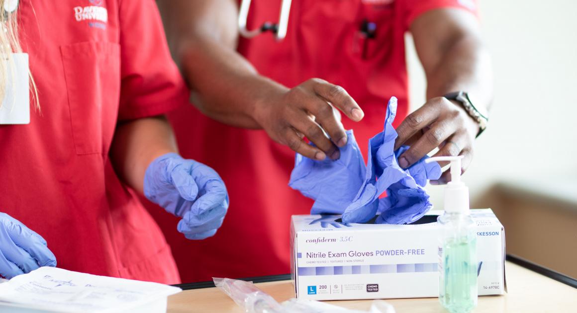 DU nursing students putting on latex gloves