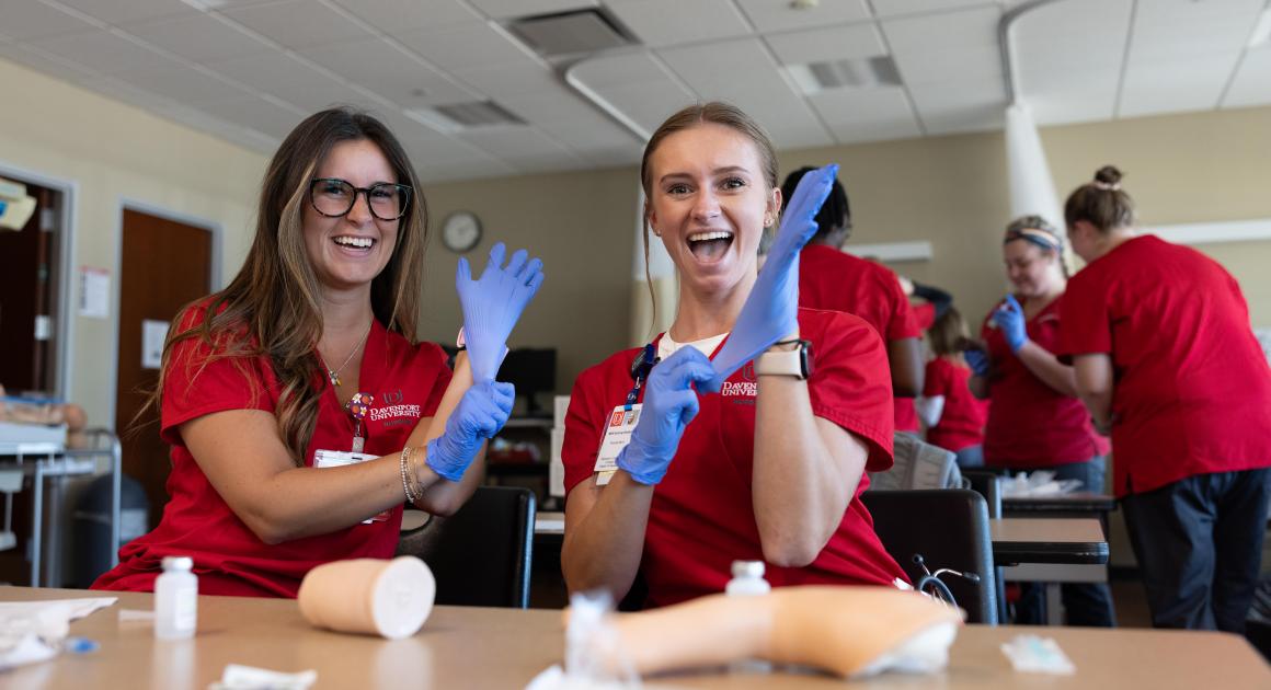 Two nursing students with latex gloves on 