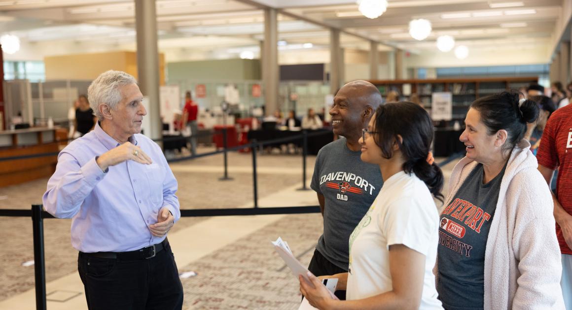 Sr. Pappas talking with a student and her parents on move in day