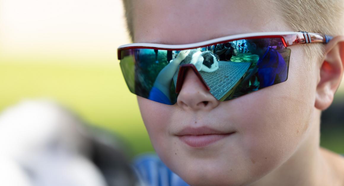 Up close imagine of a young boy with sunglasses and petting a bunny at Pounce's Family Fun Day 