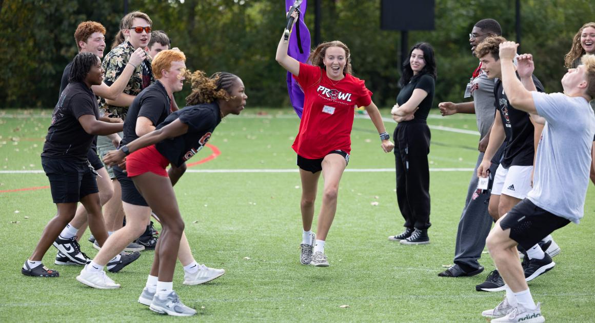 A group of students on the athletic field cheering during Panther Prowl