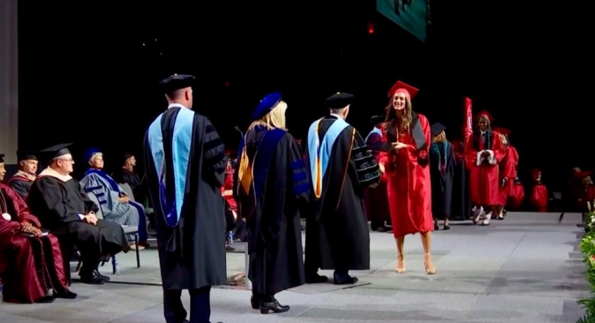 Student walking across the stage at 2025 commencement